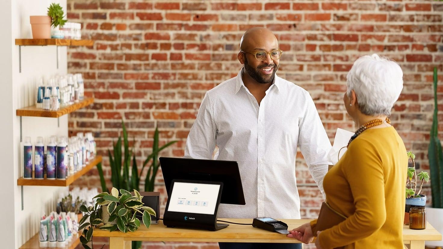 Customer and local business staff member at checkout after a positive experience